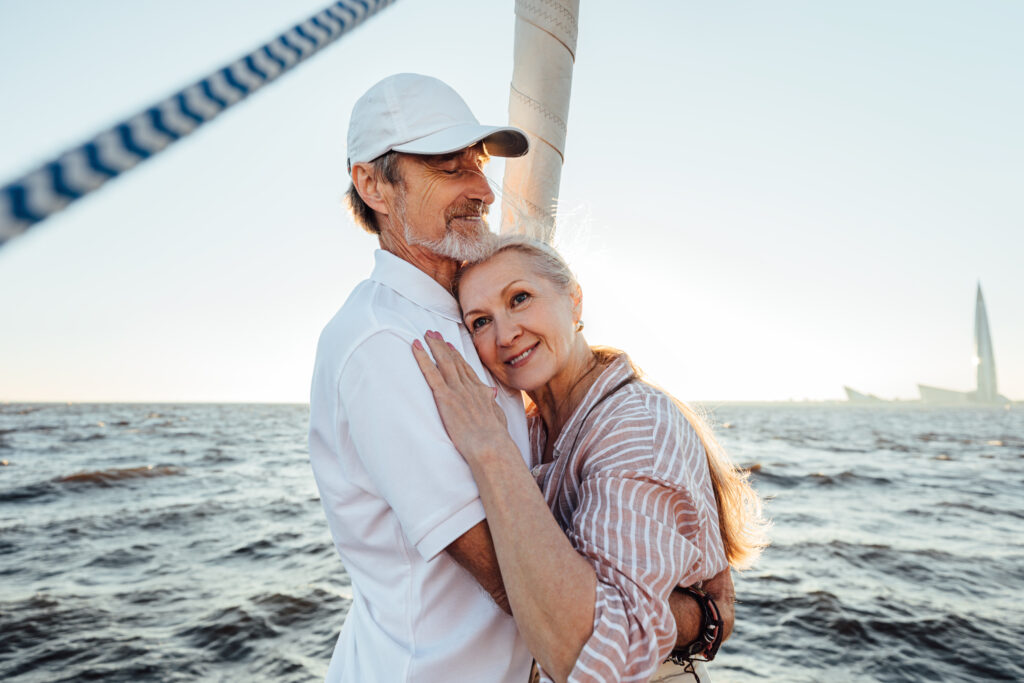 Elderly romantic couple embracing each other on the yacht bow